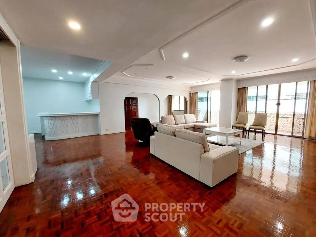 Spacious living room with elegant wooden flooring and modern furniture in a luxurious apartment.