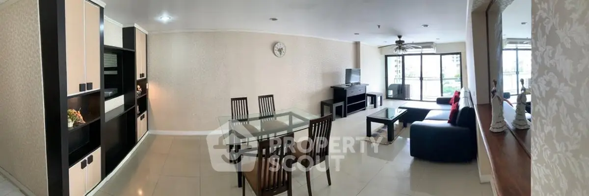 Spacious living room with modern furniture and large windows offering natural light and city views.