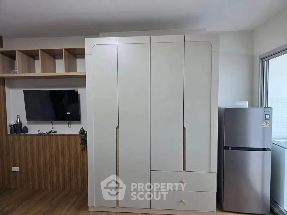 Modern apartment interior with sleek wardrobe and stainless steel fridge