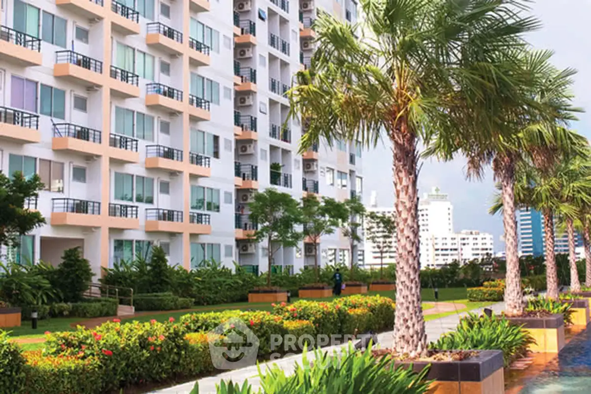 Modern apartment building with lush garden and palm trees, offering a serene urban living experience.