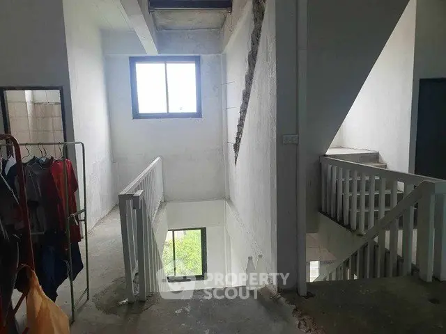 Spacious stairwell with natural light and modern railing design.