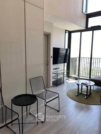 Modern living room with floor-to-ceiling windows and balcony view