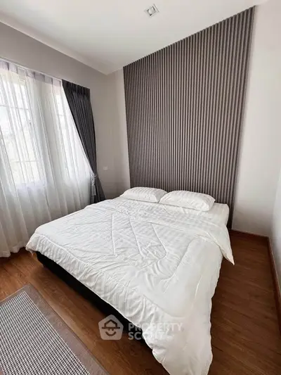 Modern bedroom with stylish accent wall and cozy bedding