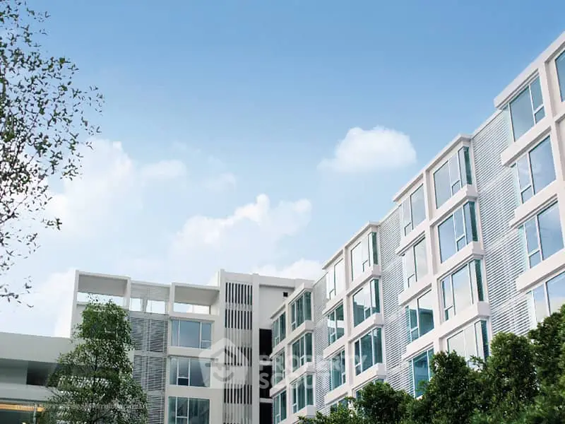 Modern apartment building with sleek design and large windows in urban setting.