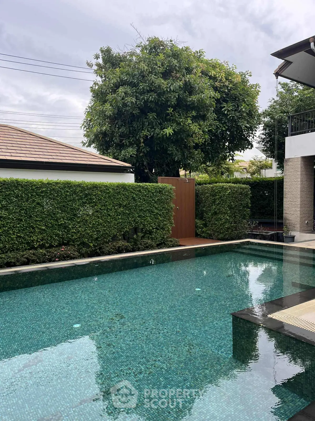 Luxurious private pool with lush greenery and modern architecture, perfect for relaxation and entertainment.