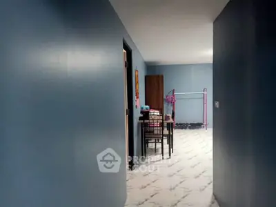 Spacious hallway leading to a cozy dining area with modern decor and marble flooring.