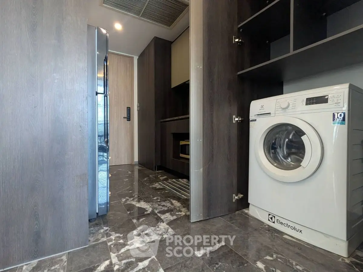 Modern laundry area with Electrolux washing machine and sleek cabinetry