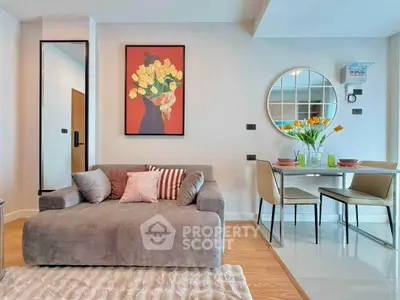 Stylish living room with modern decor and dining area, featuring a cozy sofa and vibrant artwork.