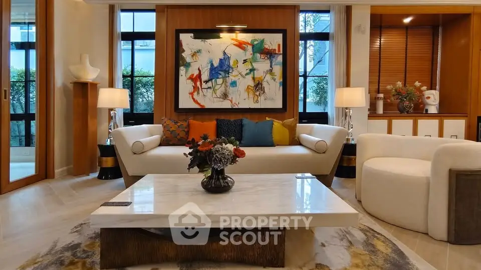 Luxurious living room with modern art, elegant furniture, and large windows for natural light.