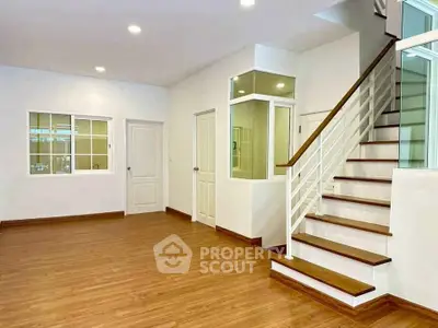 Spacious modern interior with wooden flooring and stylish staircase