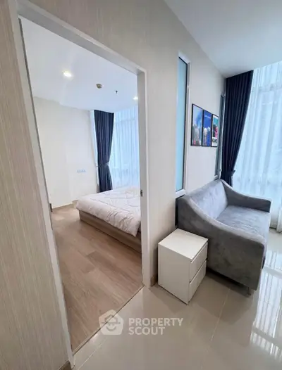 Modern apartment interior with cozy bedroom and stylish living area, featuring large windows and elegant decor.