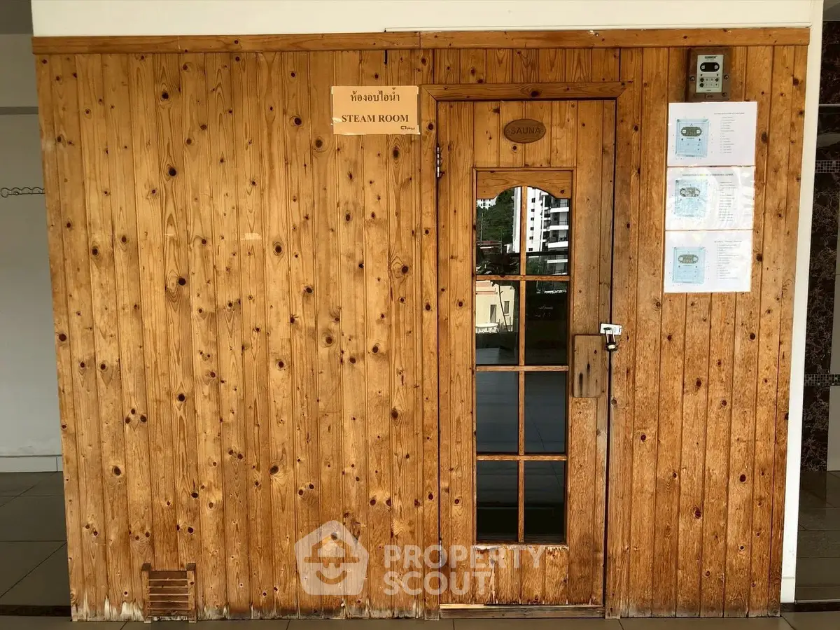 Charming wooden steam room exterior in a modern building, offering relaxation and wellness amenities.