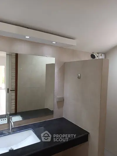 Modern bathroom with sleek black countertop and large mirror