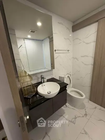 Modern bathroom with sleek design, featuring marble tiles and contemporary fixtures.