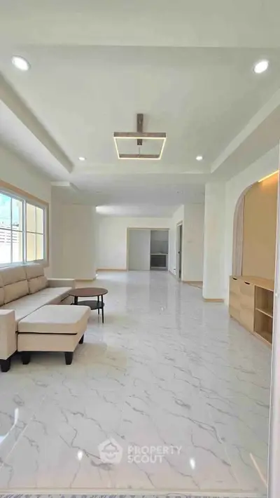 Spacious modern living room with elegant marble flooring and stylish furniture.