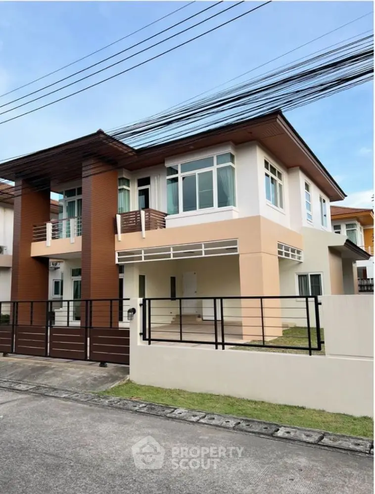 Modern two-story house with sleek design and spacious front yard in a suburban neighborhood.