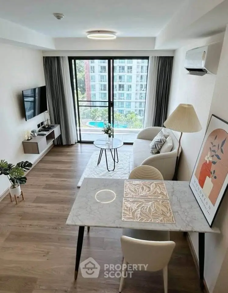 Modern living room with stylish decor and large window offering a stunning view of the cityscape.