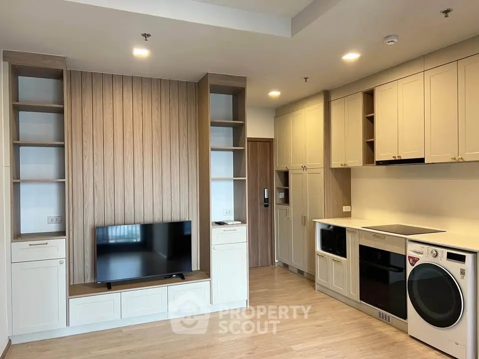 Modern living room with built-in entertainment center and sleek kitchen appliances