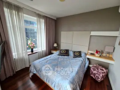 Cozy bedroom with elegant decor and large window offering natural light.
