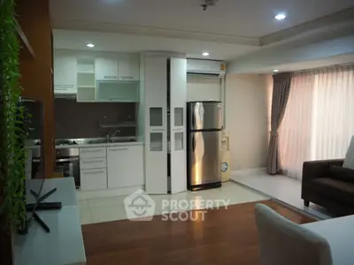 Modern open-plan kitchen and living area with sleek appliances and cozy seating.
