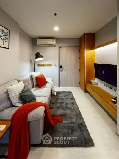 Modern living room with cozy sofa, stylish decor, and wall-mounted TV in a chic apartment.