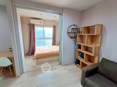 Modern apartment interior with bedroom and living area, featuring stylish furniture and large window view.