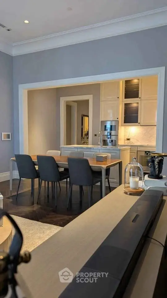 Elegant dining area with modern kitchen, featuring sleek cabinetry and stylish decor.