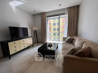 Modern living room with sleek furniture and large window offering natural light.