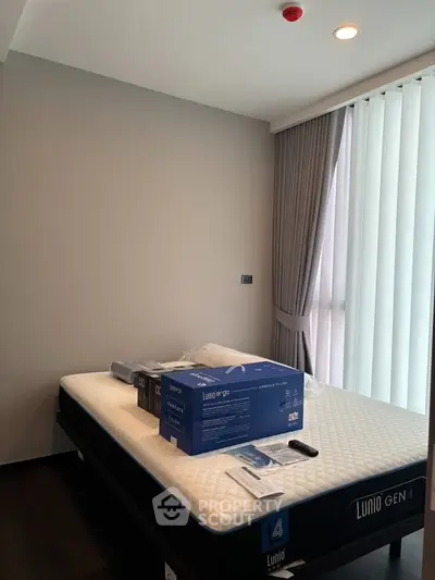Modern bedroom with new mattress and floor-to-ceiling windows in a stylish apartment.