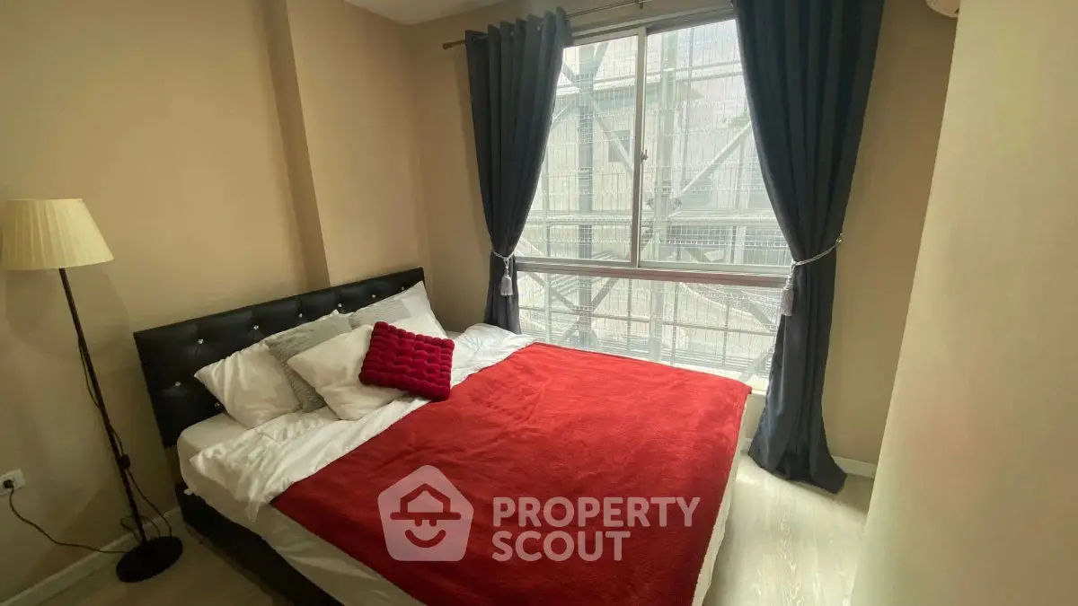 Cozy bedroom with large window and stylish decor in modern apartment