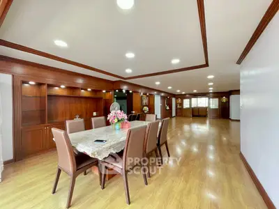 Spacious dining area with elegant wooden flooring and built-in cabinets, perfect for family gatherings.
