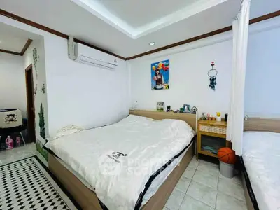 Cozy bedroom with modern decor and air conditioning, featuring a comfortable bed and stylish accents.