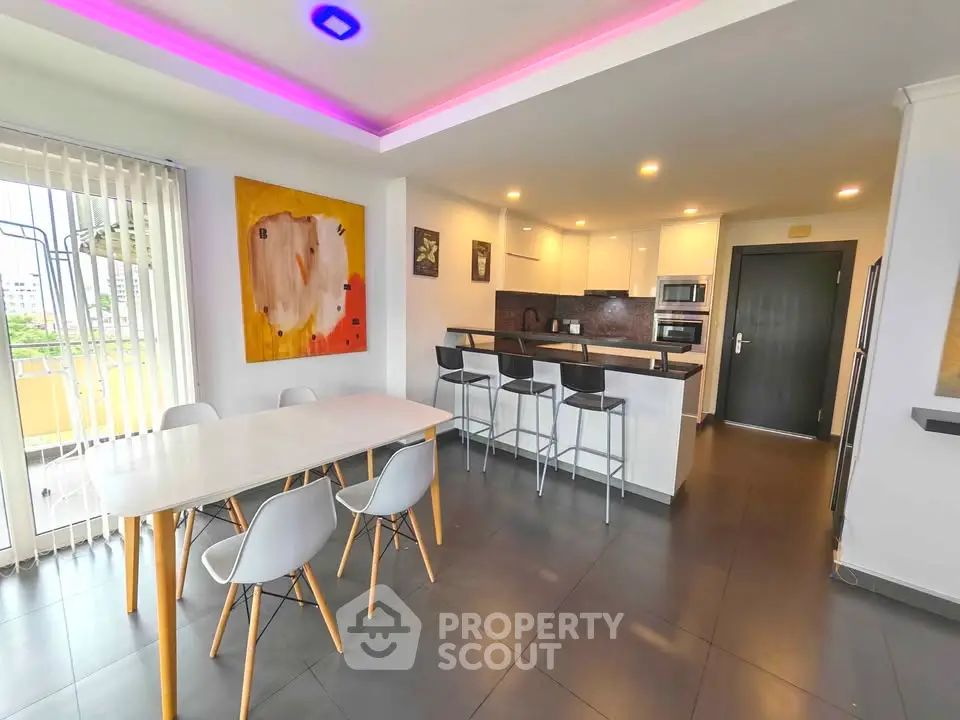 Modern open-layout kitchen and dining area with stylish lighting and contemporary decor.
