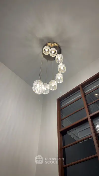 Elegant modern chandelier in a stylish interior setting with wooden accents.