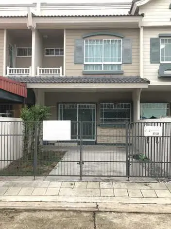 Charming townhouse exterior with gated entrance and balcony, perfect for modern living.