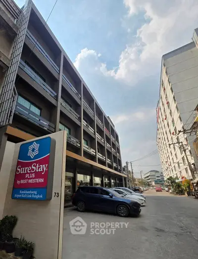 Modern hotel exterior with ample parking in bustling Bangkok location
