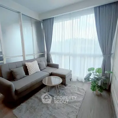 Bright and cozy living room with modern gray sofa and large window.