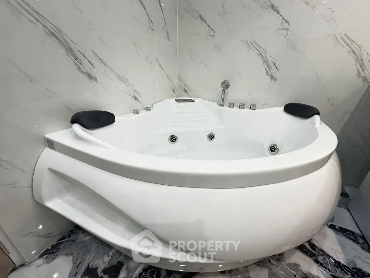 Luxurious modern bathtub in elegant marble-tiled bathroom