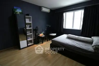 Spacious bedroom with modern decor and natural light, featuring a comfortable bed and stylish furnishings.