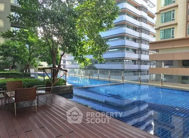 Luxurious apartment complex with a stunning outdoor pool and modern architecture.