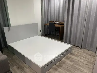 Modern bedroom with minimalist bed frame and study desk, featuring elegant gray curtains.