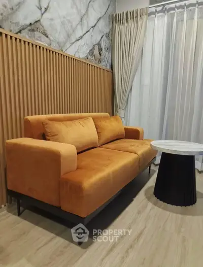 Stylish living room with modern orange sofa and elegant marble accent wall