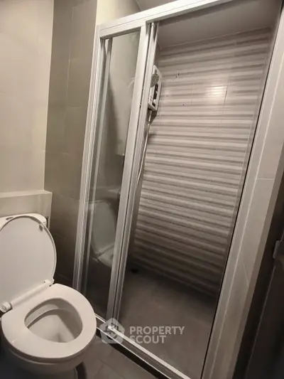 Modern bathroom with sleek shower and toilet in contemporary design.
