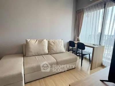 Modern living room with cozy beige sofa and city view from large window, perfect for urban living.
