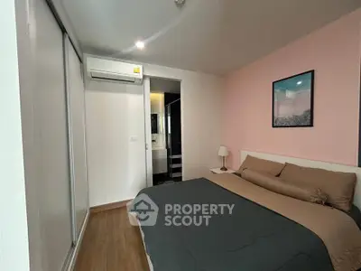 Cozy bedroom with modern decor and ensuite bathroom in stylish apartment.