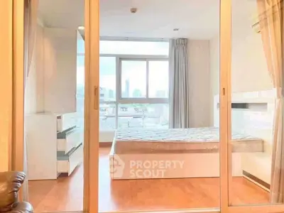 Modern bedroom with large windows and sliding glass doors, offering a bright and airy ambiance.