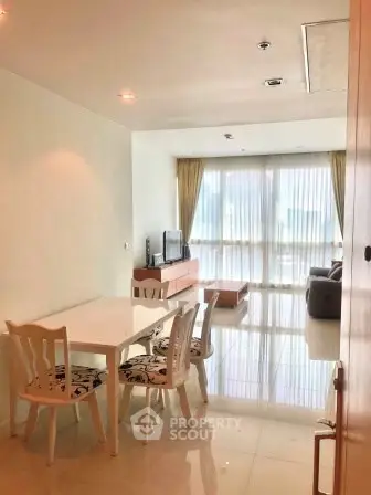 Spacious living room with dining area and large windows in modern apartment.