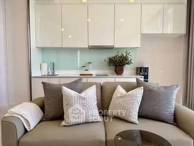 Modern living room with stylish sofa and sleek kitchen backdrop, perfect for contemporary living.