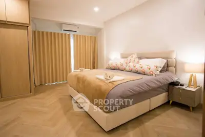 Spacious bedroom with elegant decor and natural light, featuring a cozy bed and stylish furnishings.