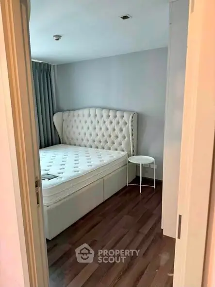 Cozy bedroom with elegant tufted headboard and hardwood flooring